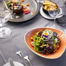 Gemischter Salat und ein Steakgericht auf einem gedeckten Tisch im Restaurant