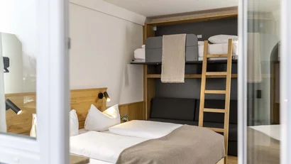 Bett mit Kissen und Leiter zum Hochbett in modernem Schlafzimmer