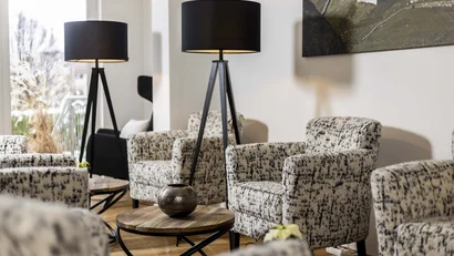 Moderne Zimmer mit gemusterten Sesseln und schwarzen Stehlampen