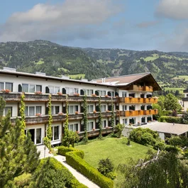 Hotelgebäude mit Balkonen und Bergblick im Sommer