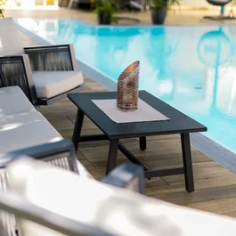 Moderne Gartenmöbel neben einem Pool mit dekorativer Laterne auf Tisch
